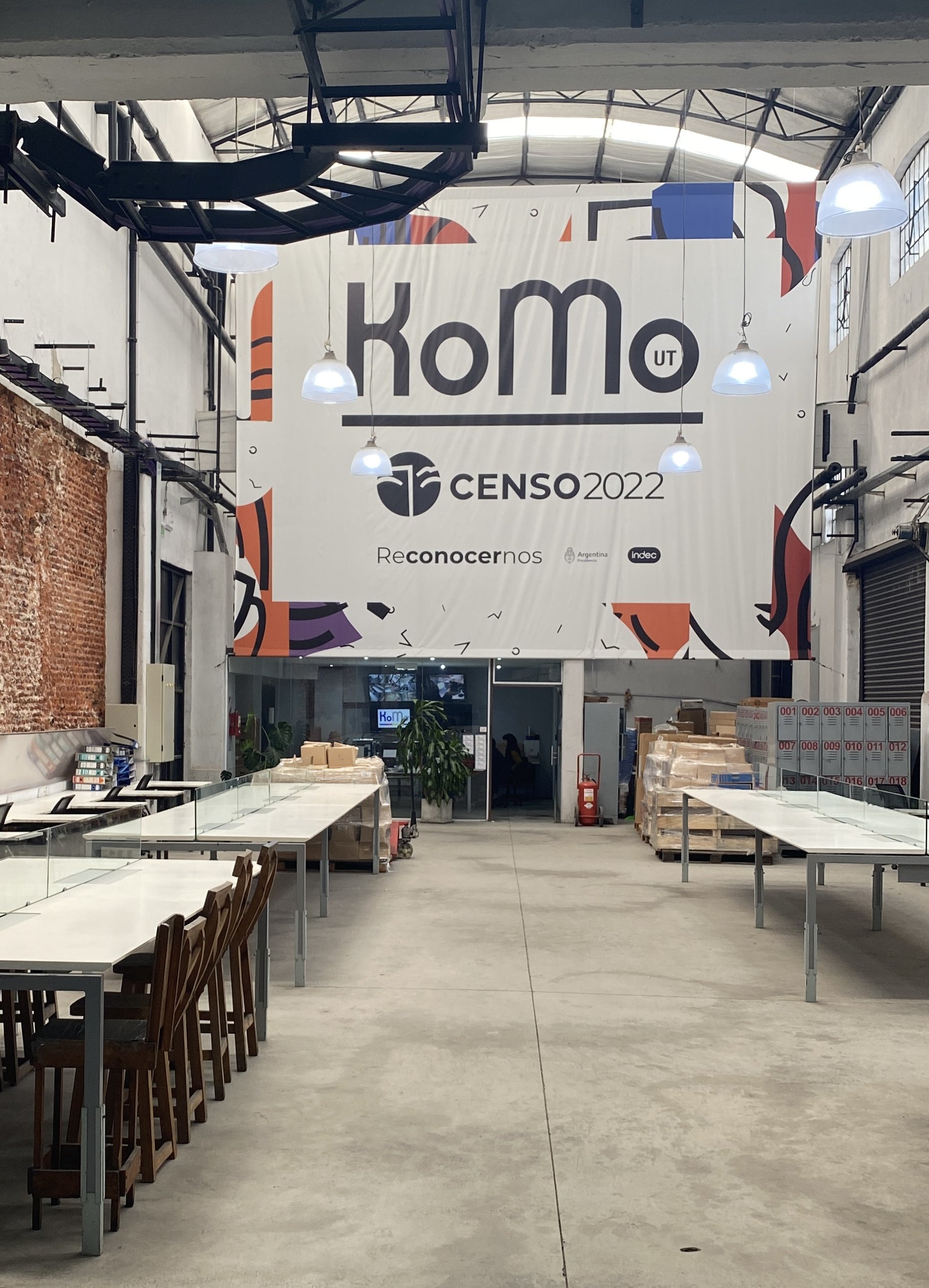 Planta de KoMo durante el operativo del Censo Nacional 2022 — banner KoMo · INDEC · Presidencia colgado sobre el área de producción en Avellaneda